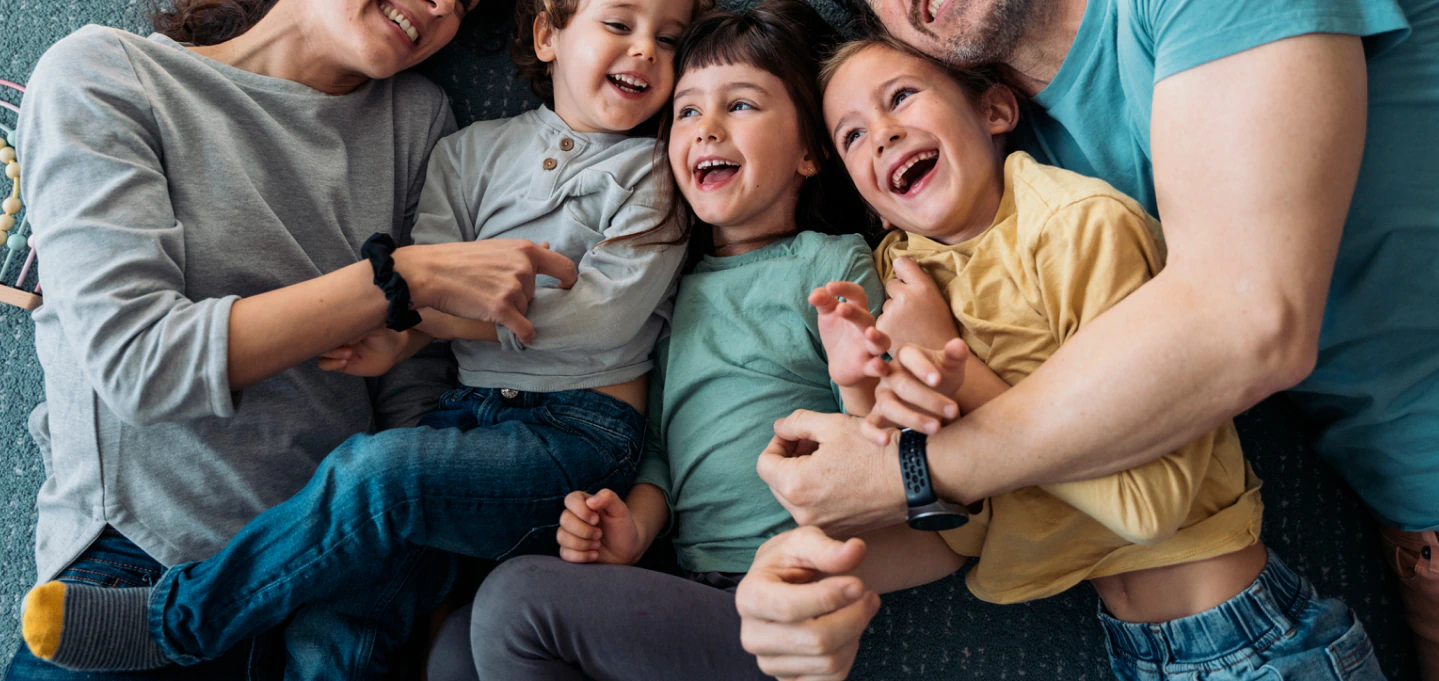 Family laying on the floor smiling.